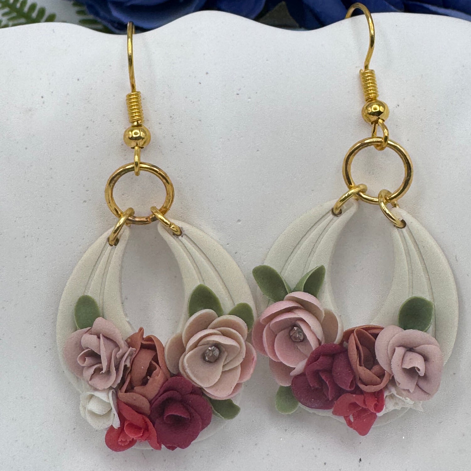 Floral earrings with gold hooks on a white background